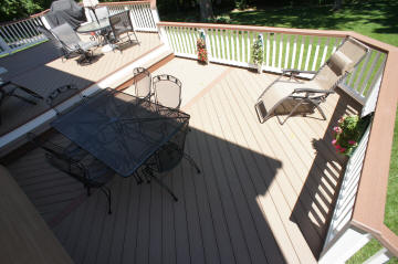 large multi level composite deck with herringbone floor pattern white fascia white vinyl rails multi color